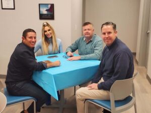 group of people sitting at a table at the Grand Opening of the new Bridge Back To Life Center facility in Bethpage, New York